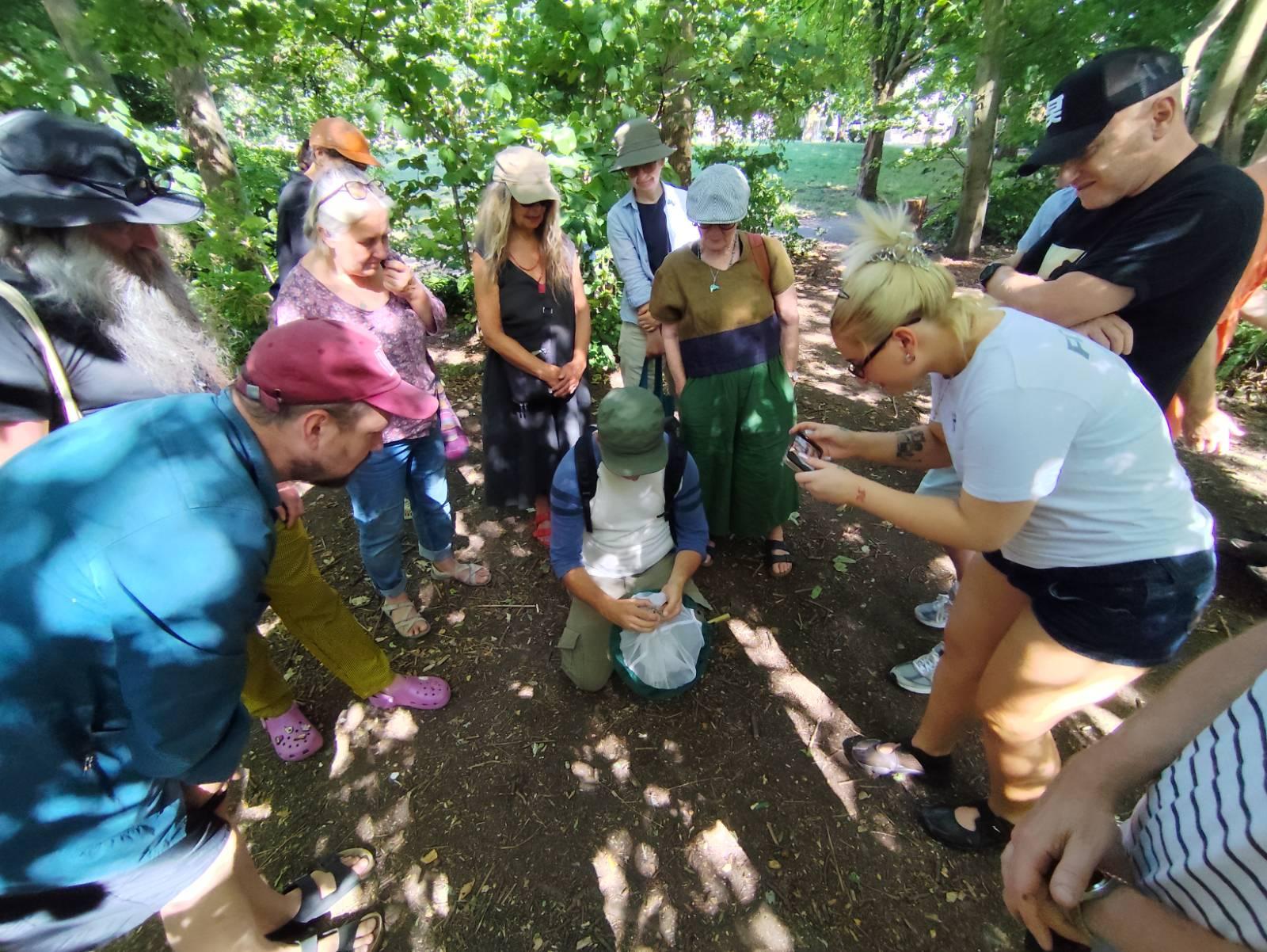 Participants surrounding Ian looking at the Tiger Moth he'd just netted